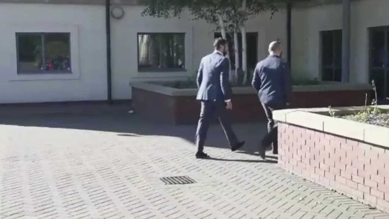 Still from video.mp4 @1s - two advisers walking outside the office